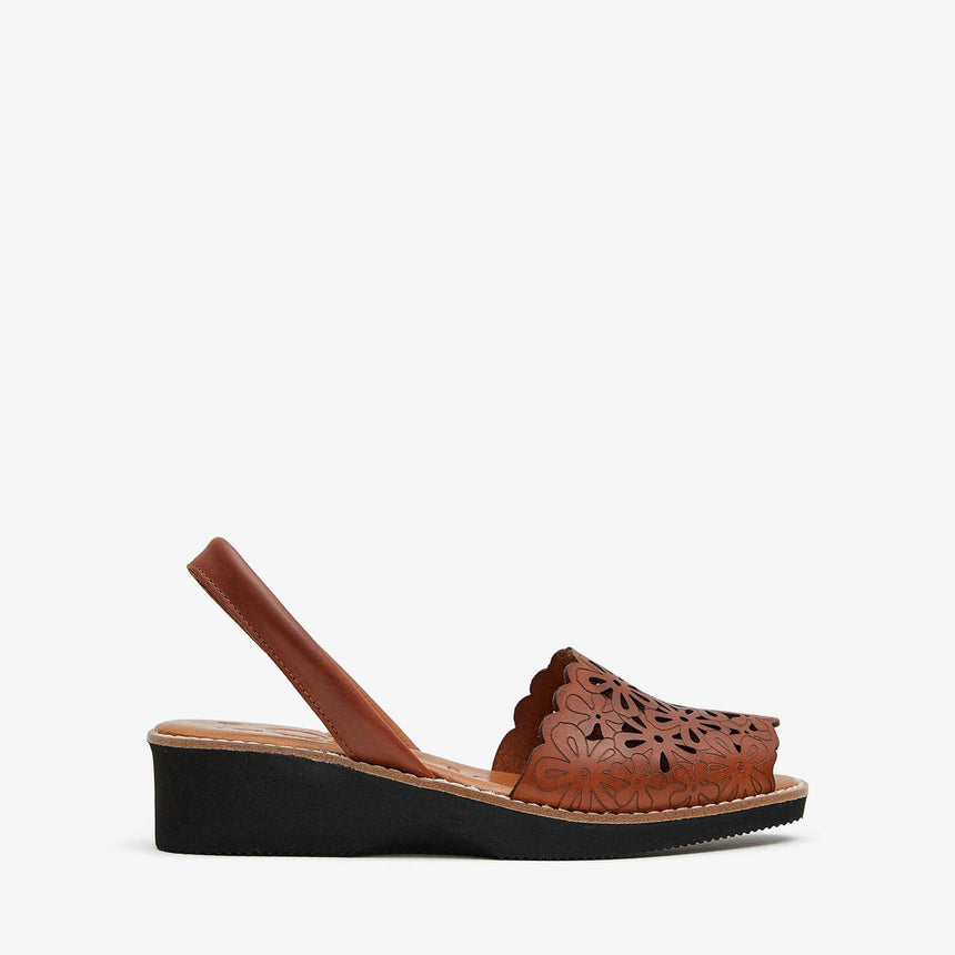 Sandalia menorquina lola Almagro con cuña y grabados florales en la sandalia color cuero vista desde el lateral