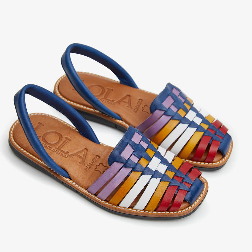 Menorquinas planas de piel  con pala trenzada con una combinación de colores de rojo,naranja,blanco y magenta vista de cerca desde el ángulo frontal