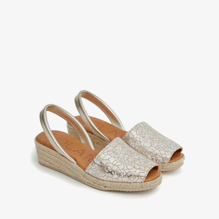 Menorquinas con cuña de piel con pala de color platino con efecto craqueado y piso de yute vista desde el ángulo frontal