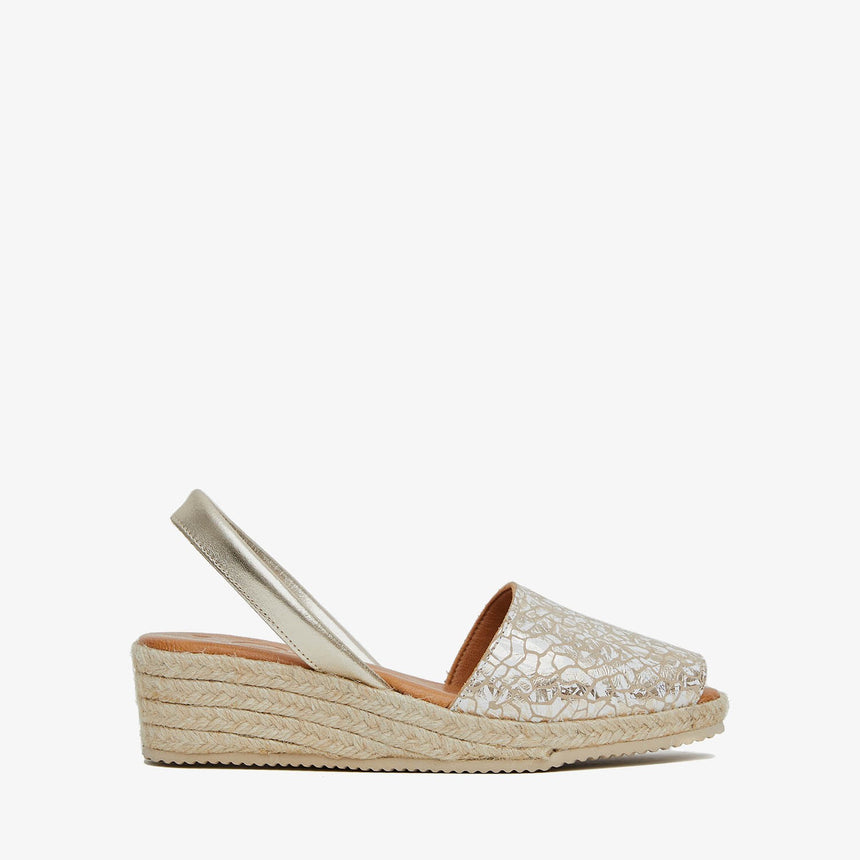 Menorquinas con cuña de piel con pala de color platino con efecto craqueado y piso de yute vista desde el lateral