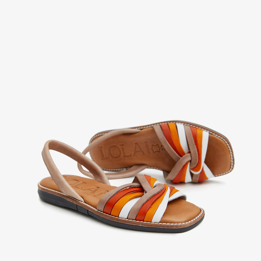 Menorquinas planas de piel con pala trenzada con una combinación de colores de blanco,naranja,rojo y marrón vista desde el ángulo lateral de una manera creativa