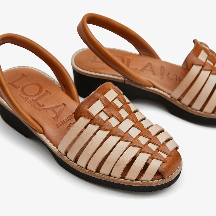 Sandalias menorquinas con cuña con una combinación de colores trenzada arena y avellana vista desde un ángulo lateral