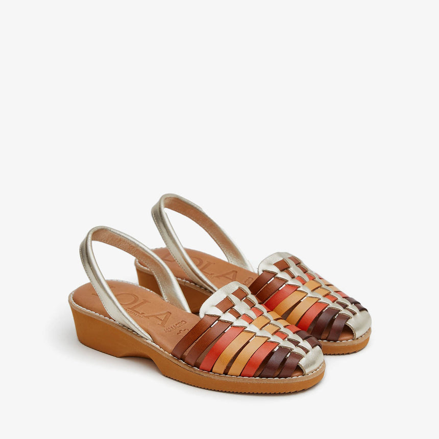 Menorquinas con cuña de piel con pala trenzada con una combinación de colores de marrón, naranja, amarillo y piso de color caramelo vista desde el ángulo frontal