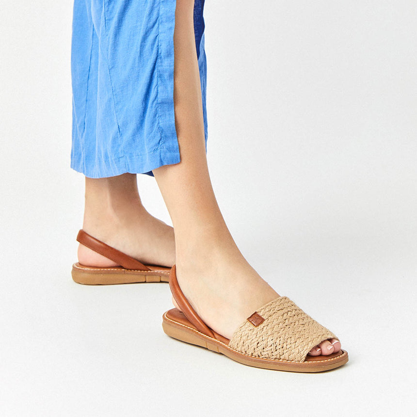 Menorquinas planas de piel con pala de yute puestas en los pies de una modelo vista desde el ángulo frontal