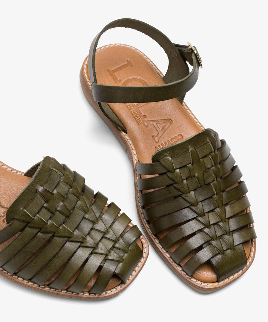 Sandalia de piel plana de color verde con hebilla con pala trenzada vista desde arriba creativa