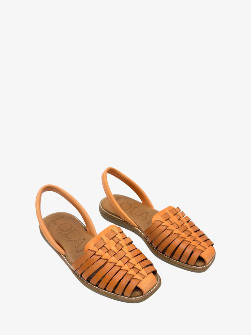Vista aérea de sandalia plana BINIGAUS en piel color manda, diseño artesanal con trenzado clásico.