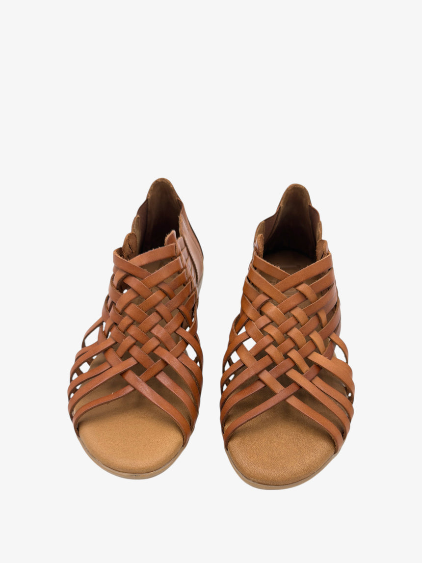 Vista frontal de sandalia TONNARELLA plana en cuero, con trenzado envolvente y puntera abierta.