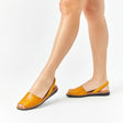 Menorquinas planas de piel de color panama puestas en los pies de una modelo vista dese el ángulo frontal